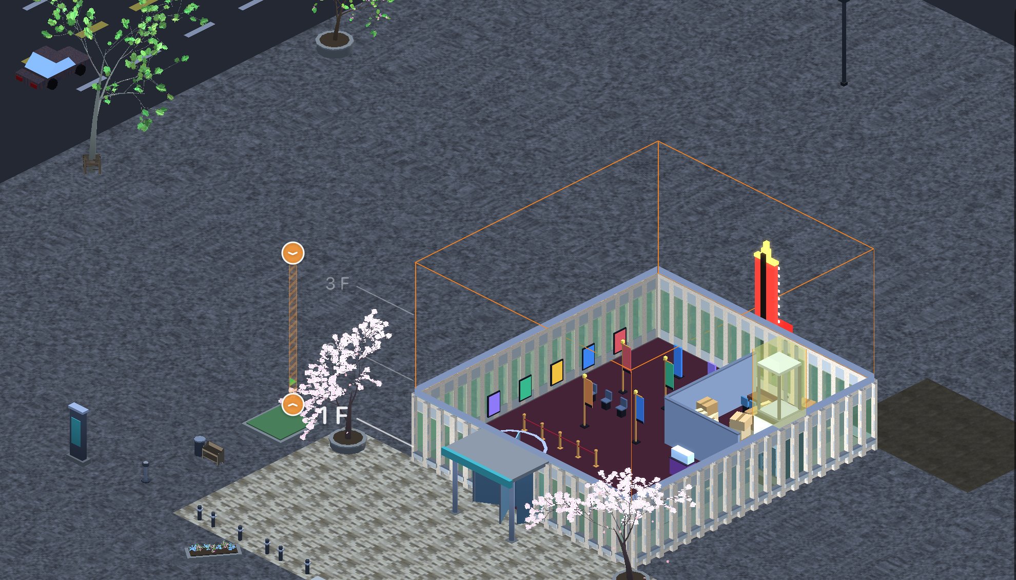 A small cinema building with a paved forecourt, planters, a waiting shelter and blossom trees